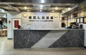 a counter in a room with clocks on the wall at Green Yard Business Hotel in Miaoli