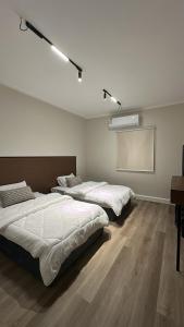 two beds sitting in a room with a projector at شقق مخدومة in Jazan