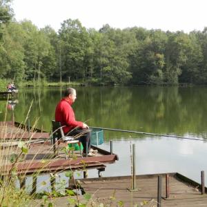 a man sitting on a dock fishing on a lake at Arden Parks Baalse Hei in Turnhout +12 photos