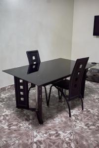 a black desk with a black chair in a room at Niyonest Guesthouse in Harare