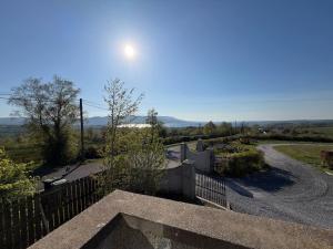 a house with a fence and a road at The Hilltop Hideaway in Enniskillen