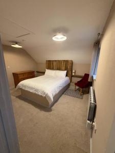 a small bedroom with a bed and a chair at The Hilltop Hideaway in Enniskillen