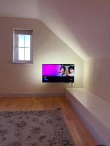 a living room with a flat screen tv on a wall at The Hilltop Hideaway in Enniskillen