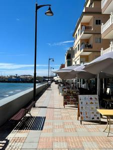 a sidewalk with tables and umbrellas next to a building at Casa Veronica in Arona