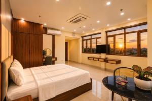 a bedroom with a bed and a table and a television at O Lily Hotel in Ninh Binh