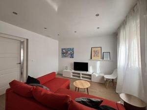a living room with a red couch and a tv at Casa Damián in Ribaforada