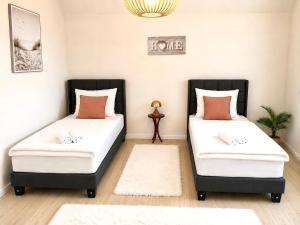 two beds in a room with white and orange pillows at Top Wohnung, auch für Monteure in Siegen-Wilnsdorf Autobahn in Wilnsdorf
