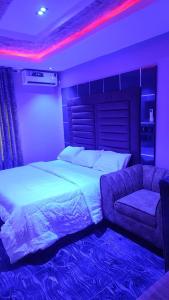 a bedroom with a bed and a couch at Daikon Garden Hotel in Ekwulobia +10 photos