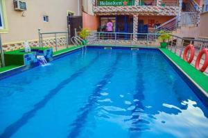 a large pool with blue water in front of a building at Daikon Garden Hotel in Ekwulobia