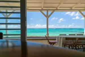 a dining room with a table and a view of the ocean at La Plage I Beachfront Villa on the Lagoon in Centre de Flacq