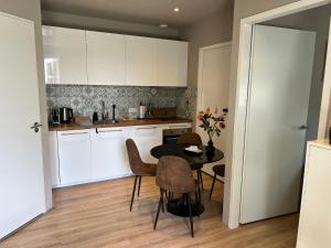 a kitchen with a table and chairs in a room at Etoile aan Zee in Vrouwenpolder