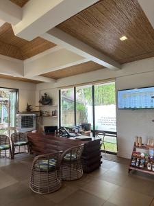 a room with chairs and a table and some windows at Bacau Bay Resort Coron in Coron