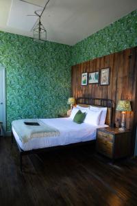 a bedroom with a bed with a green accent wall at Hinds Head in Aldermaston +89 photos