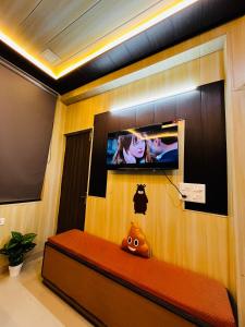 a room with a tv on a wall with a bench at Oakèra in Agra