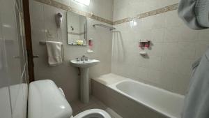 a bathroom with a sink and a toilet and a bath tub at Hotel coventry in Santiago del Estero
