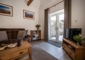 a living room with a couch and a tv at Greenacres in Kelsale