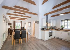a kitchen and living room with a table and chairs at Greenacres in Kelsale