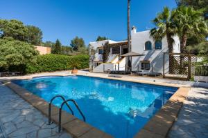 a swimming pool in front of a house at Asteria Eco Finca Sustainable 6 Bedroom Nature Retreat near UNVRS Ibiza in Santa Gertrudis de Fruitera