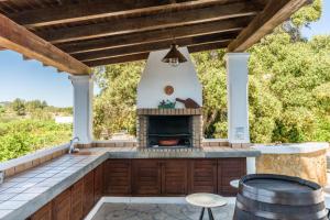 an outdoor kitchen with a fireplace on a patio at Asteria Eco Finca Sustainable 6 Bedroom Nature Retreat near UNVRS Ibiza in Santa Gertrudis de Fruitera