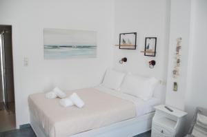 a white bedroom with a bed with towels on it at Giorgantis Studio II in Plaka Milou