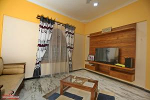 a living room with a couch and a tv at Europenvilla in Mannar