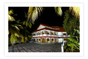 a large white building with a red roof at Europenvilla in Mannar