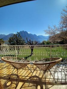 a patio with two chairs on a deck with mountains in the background at Casa Vacanze Cael la Quiete in Riva di Solto
