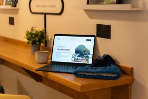 a laptop computer sitting on a wooden desk at Base Dingle in Dingle