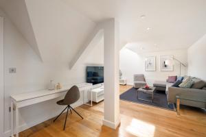 a white living room with a couch and a tv at Wren Urban Nest in Dublin