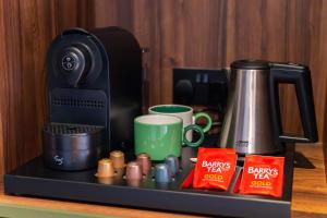 a counter with a coffee maker and cups on it at Base Dingle in Dingle