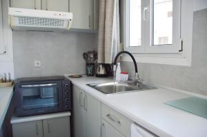 a kitchen with a sink and a microwave at Giorgantis Studio II in Plaka Milou