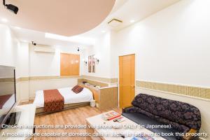 a hotel room with a bed and a couch at パティオアネックス -大人専用- in Fuefuki