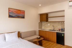 a small room with a bed and a kitchen at Bluzen Hotel in Danang