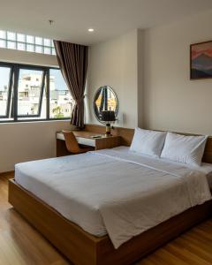 a bedroom with a large bed and a desk at Bluzen Hotel in Danang +55 photos