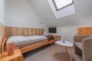 a bedroom with a bed and a couch and a tv at Penzion Vila Machů in Kopřivnice