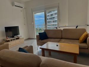 a living room with two couches and a tv at Sea view Appartment in Shëngjin