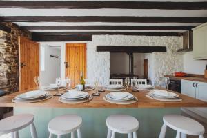 a kitchen with a table with white plates and stools at Plasbach Cottage in Llandeilo