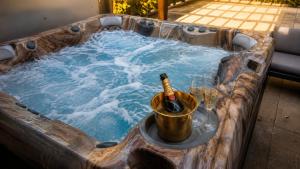 a hot tub with a bottle of wine and glasses at Fleiš Residence villa - jacuzzi included in Most
