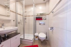 a bathroom with a shower and a toilet and a sink at Gästehaus Wolfgang Taubensee in Ruhpolding