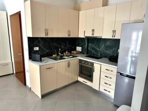 a kitchen with white cabinets and a stainless steel refrigerator at Sea view Appartment in Shëngjin