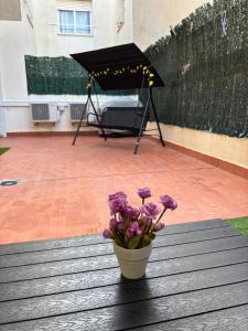 a vase of purple flowers on a table with an umbrella at El Patio de Chus by Clabao in San Javier +16 photos