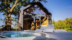 a house with a hot tub on a patio at Leśne Szepty Resort in Zebrzydów
