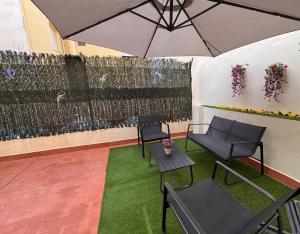 a patio with two chairs and an umbrella at El Patio de Chus by Clabao in San Javier