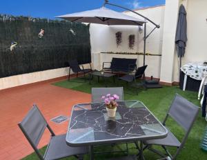 a glass table with a vase of flowers on it at El Patio de Chus by Clabao in San Javier