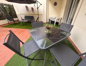 a glass table with chairs and a vase of flowers on it at El Patio de Chus by Clabao in San Javier