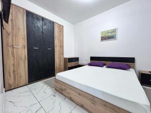 a bedroom with a large bed and wooden cabinets at Marina Evo Apartments in Mamaia Sat/Năvodari