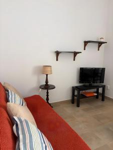 a living room with a couch and a tv at Cabo de Sagres -1 bedroom apartment in Sagres