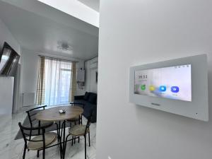 a living room with a table and a tv on a wall at Marina Evo Apartments in Mamaia Sat/Năvodari