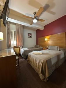 a hotel room with two beds and a ceiling fan at Hotel coventry in Santiago del Estero