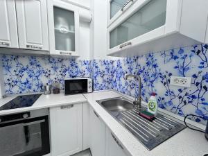 a kitchen with blue and white wallpaper and a sink at Marina Evo Apartments in Mamaia Sat/Năvodari +6 photos
